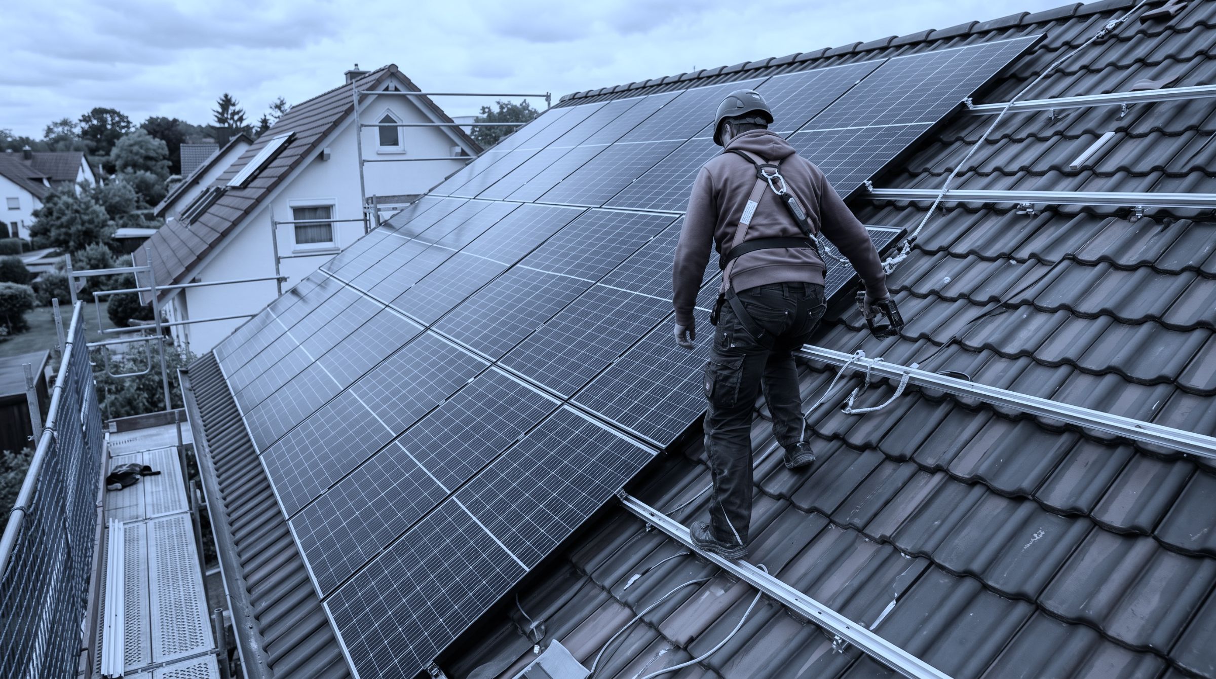 Monteur bei der Montage von Solarmodulen auf einem Hausdach